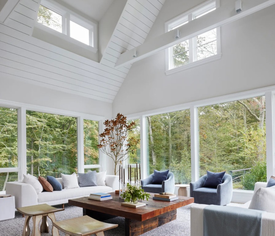 Modern sunroom interior with natural light and comfortable seating